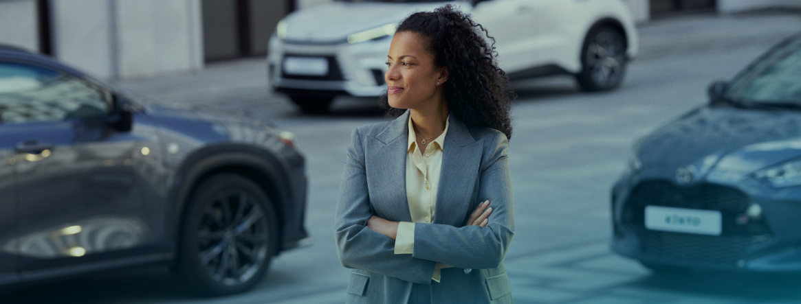 Une femme souriant devant des voitures Toyota